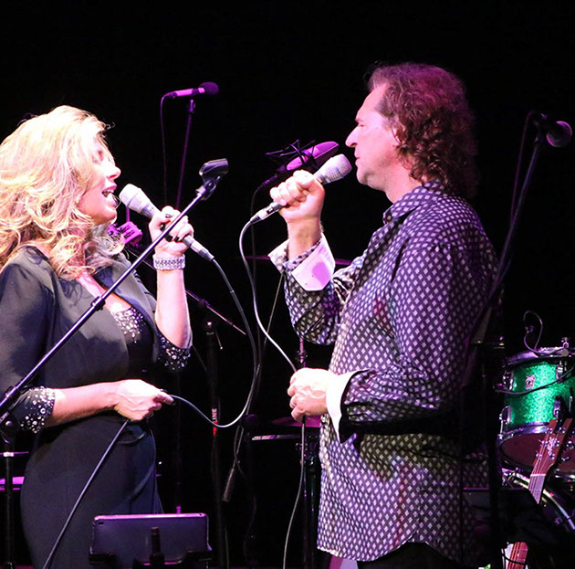 Two performers singing duet on stage
