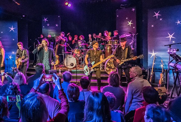 Band performing with purple and blue lighting